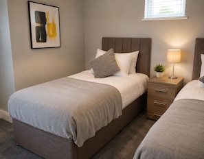 A bedroom with a bed, bedside table, lamp, and a framed artwork on the wall. - K Suites - The Hatfield Cls (Hatfield)