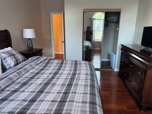 A bedroom with a large bed, a dresser, a nightstand, and a lamp. - Charming 3-bedroom house with AC in enjoyable Lexington (Lexington)