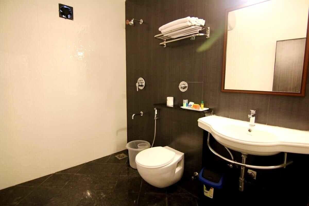 Une salle de bain avec des toilettes, un lavabo et un miroir.