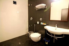 A bathroom with a toilet, sink, and mirror.