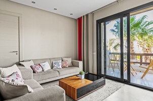 Una sala de estar moderna con un sofá, una mesita de centro y vistas al exterior.