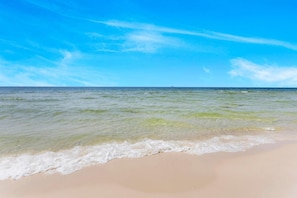 Ein Strand mit klarem Wasser und sandigem Ufer.