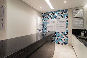 Et moderne køkken med en sort bordplade og en bagplade med geometriske mønstre.