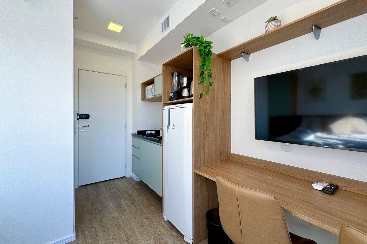 A compact kitchenette with a refrigerator, a microwave, and a coffee maker.