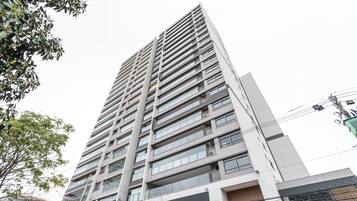En høj bygning med flere etager, altaner og et moderne arkitektonisk design.