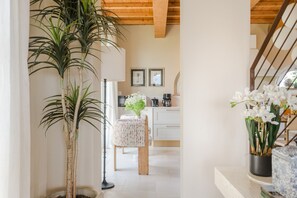 A hallway with a potted plant, a dining area with a table and chairs, and a kitchen in the background. - Villa Altavista in Montecarlo (Montecarlo)
