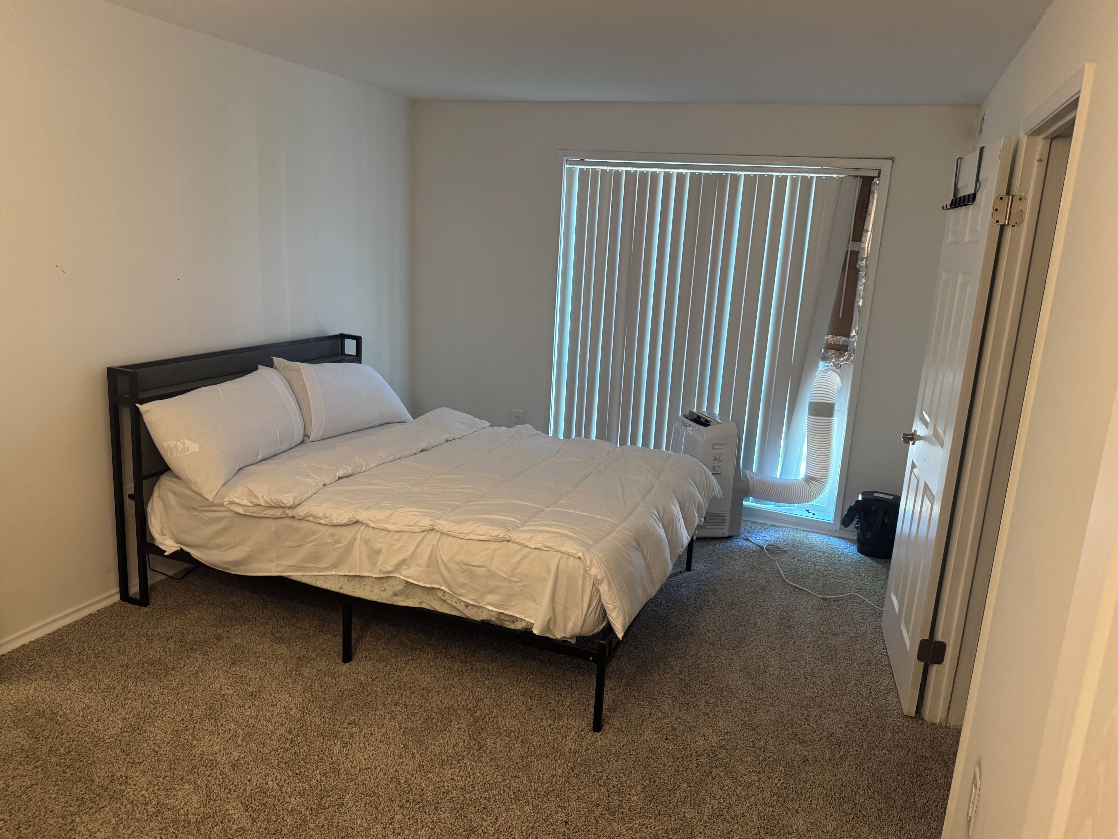 Une chambre à coucher avec un lit, un radiateur et une porte.