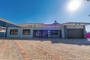 A residential building with a tiled roof, a gated entrance, and a paved driveway. - Nice 4-bedroom house in Bulawayo perfect for your getaway (Bulawayo)