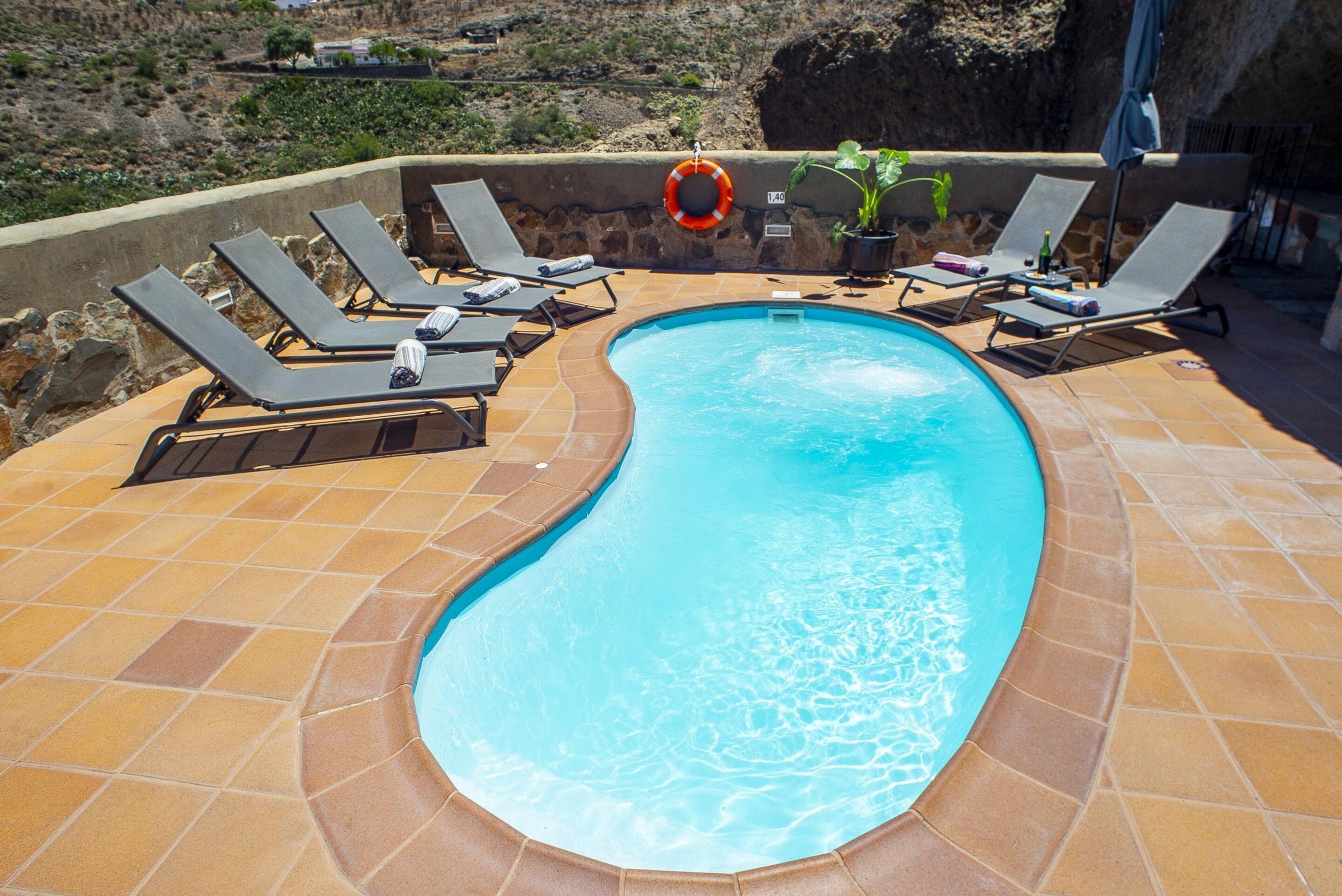 A swimming pool with lounge chairs and a lifebuoy.