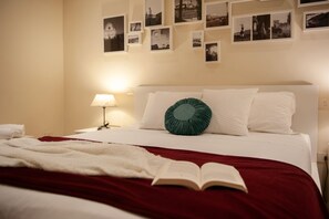 A neatly made bed with a red and white bedspread, a green circular pillow, and an open book on the bed. - Two Minutes from Florence Cathedral   San Lorenzo Terrace (FIRENZE)