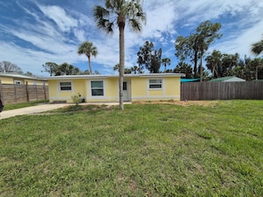 A yellow single-story house with a front yard and a wooden fence. - Cozy, family-friendly, 3-bedroom canal-front house in Nokomis 7-min to the beach (Nokomis)