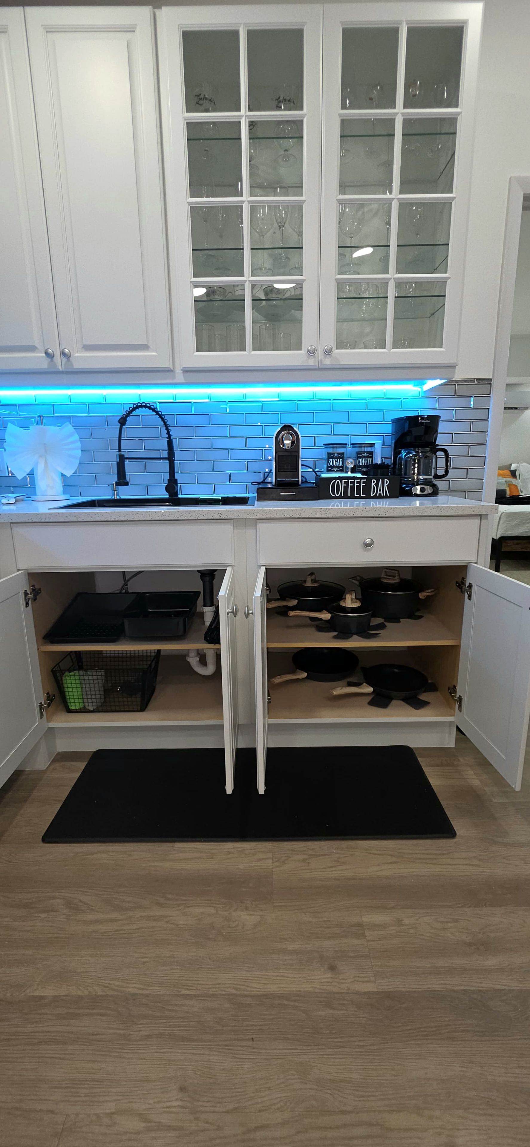 A kitchen with a coffee bar, a sink, and a window above the counter.