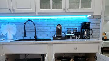 A kitchen with a coffee bar, a sink, and a window above the counter.