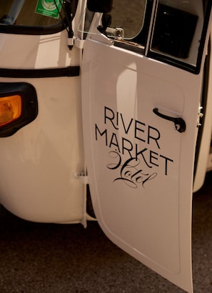 Ett fordon med en dörr som har texten ”RIVER MARKET Hotel” på sig.