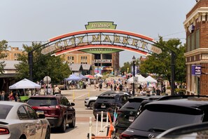 En livlig gata med en historisk portal som är försedd med inskriptionerna ”Kansas City” och ”1857”, vilket anger året då staden grundades.
