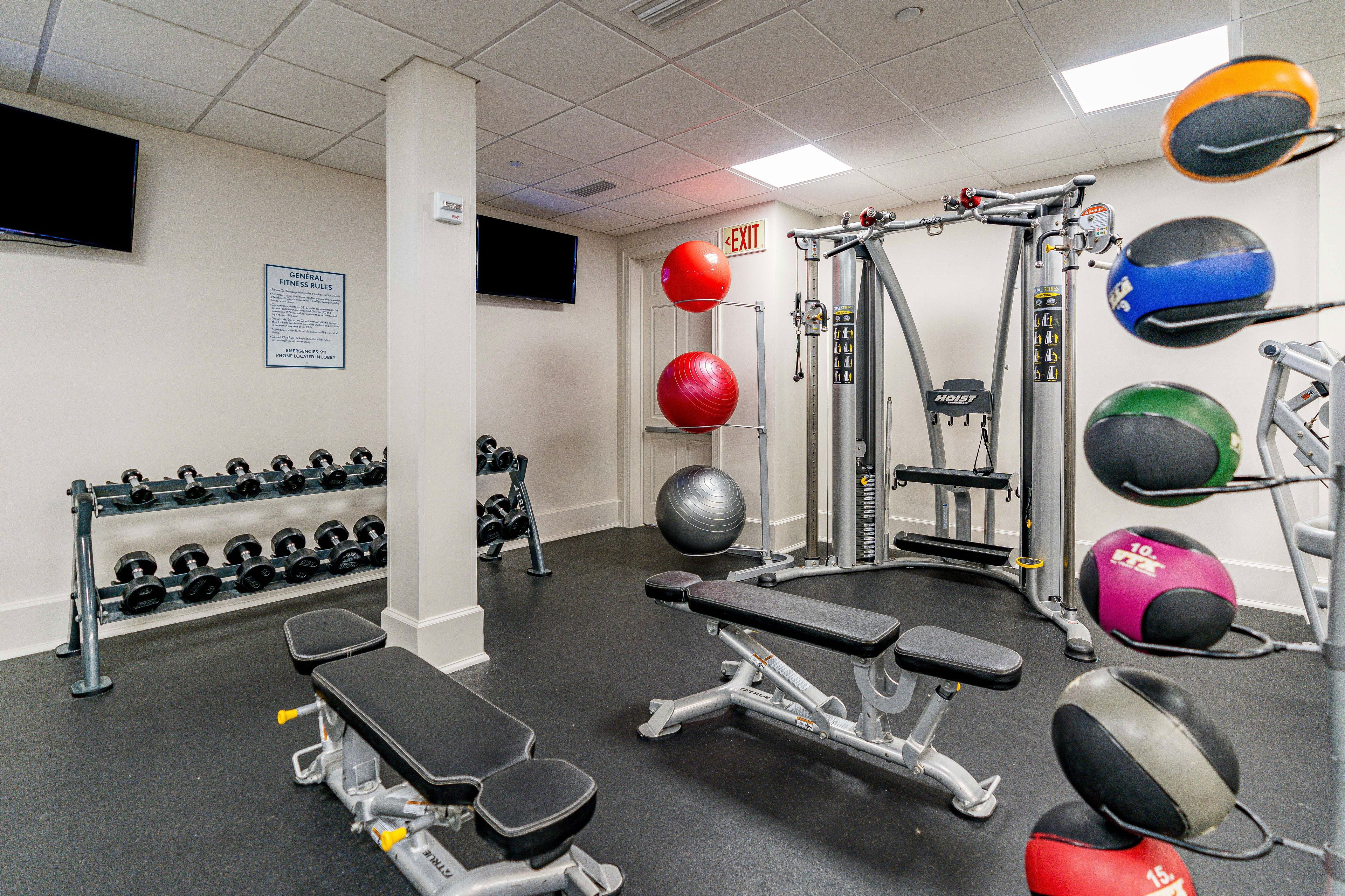 A gym with various exercise equipment, including dumbbells, medicine balls, and weight machines.