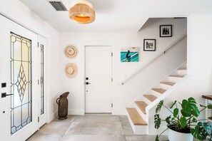A modern interior with a staircase, a door with a glass panel, and a potted plant. - St Pete Beach Waterfront Pool Hot Tub (St Pete Beach)