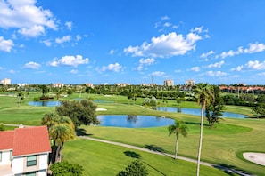 A golf course with multiple ponds, palm trees, and buildings in the background. - Bayway Isles Isla Del Sol Bahia Del Mar Pool (St Petersburg)