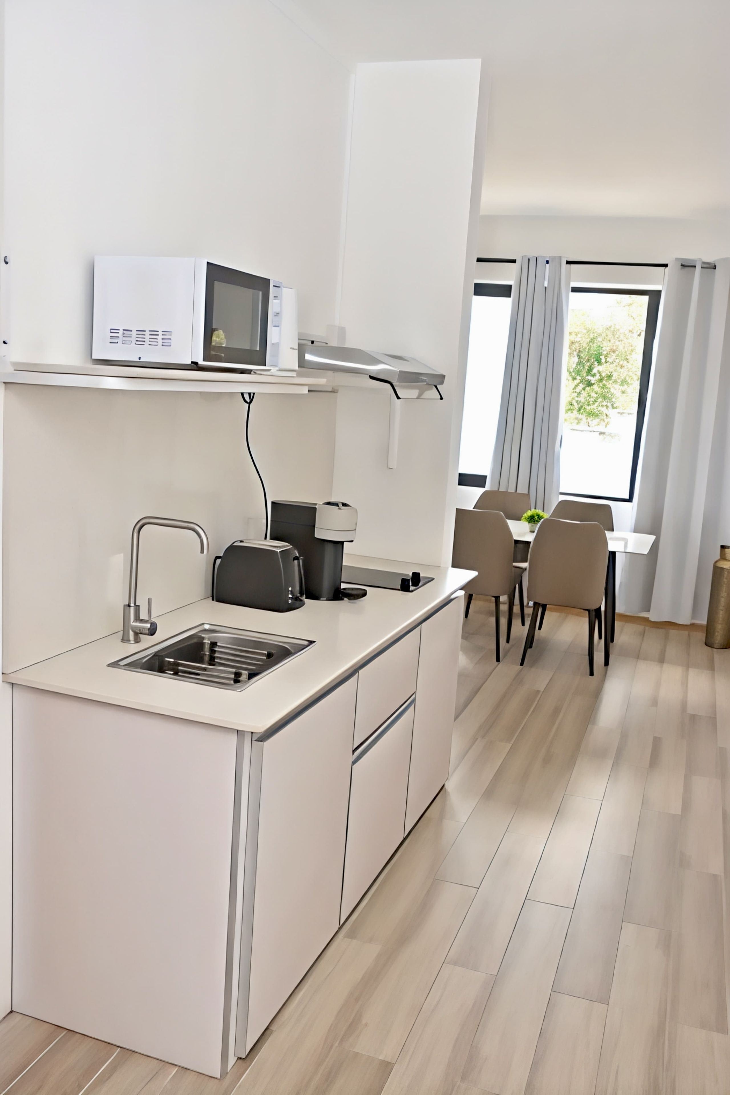 Una cocina moderna equipada con microondas, tostadora y cafetera.