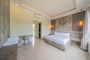 A modern bedroom with a large bed, a desk, and a chair.