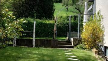 Un jardin avec un sentier de pierres menant à un escalier en bois.
