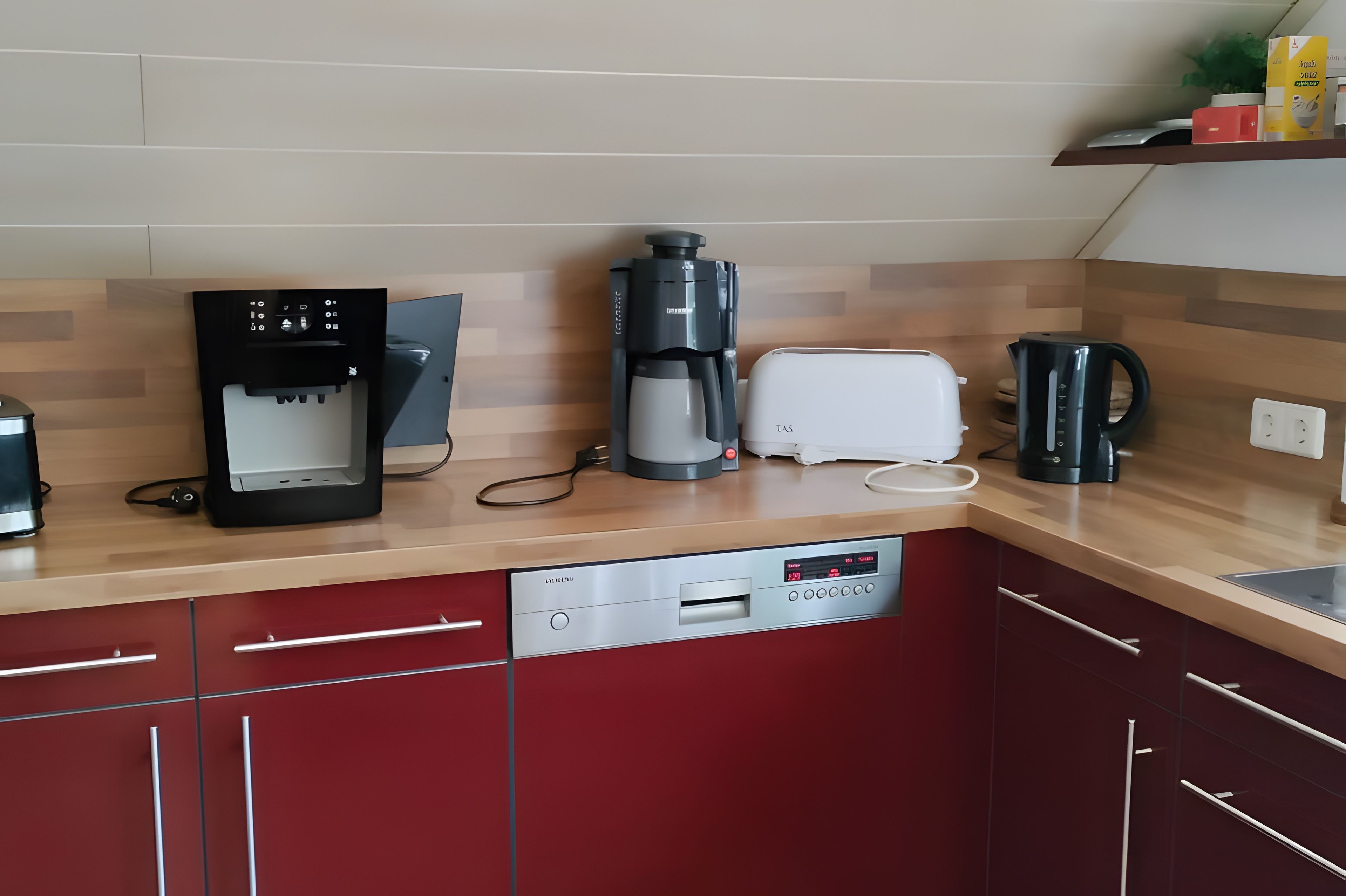 Une cuisine moderne équipée d’une machine à café, d’un grille-pain et d’un lave-vaisselle.