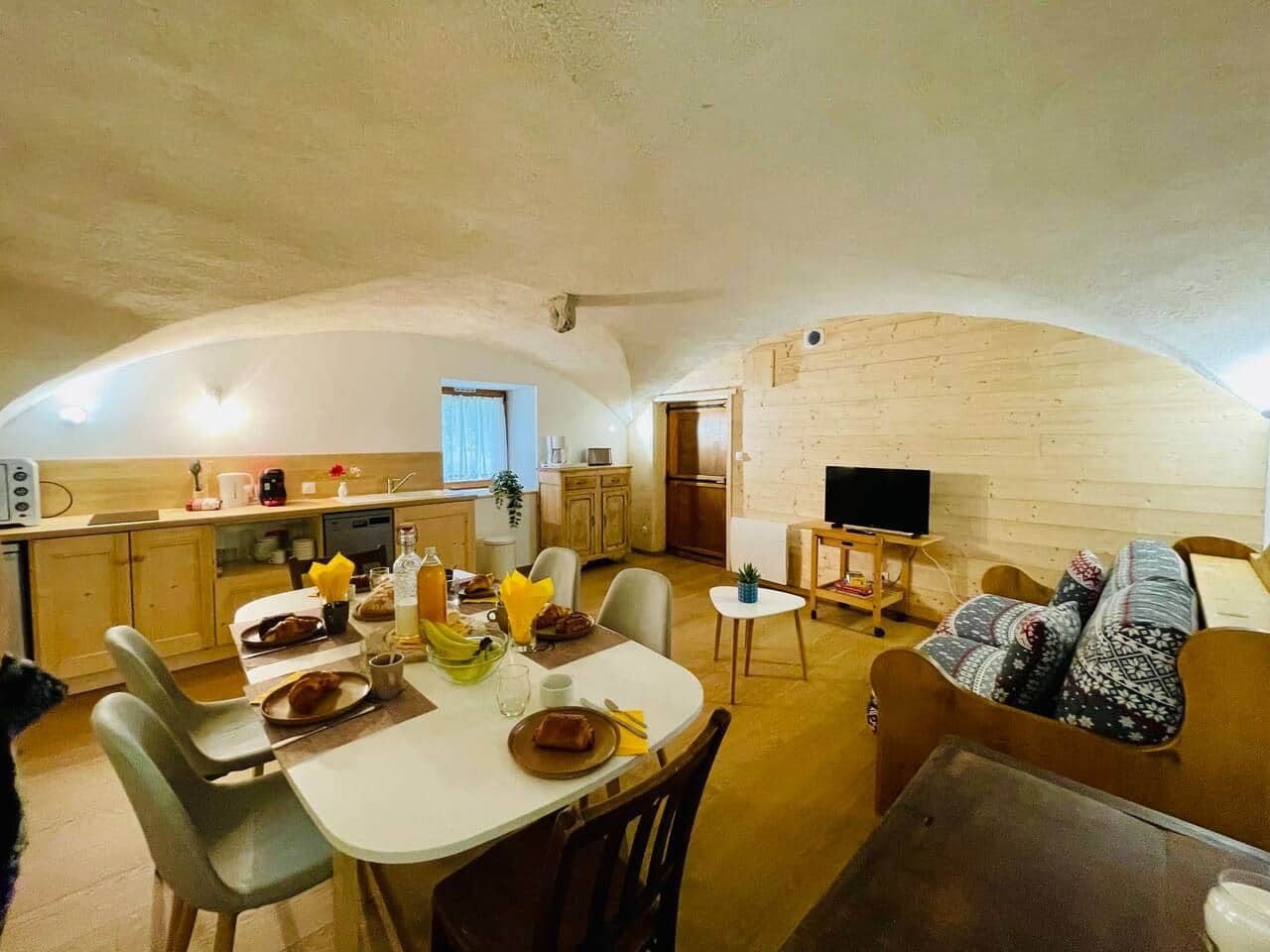 Un espace de vie compact comprenant une cuisine, un coin repas et un coin salon.