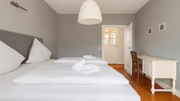A bedroom with a large bed, a desk, and a chair.