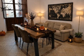 Et hyggeligt spiseområde med et træbord, stole og Halloween-pynt.