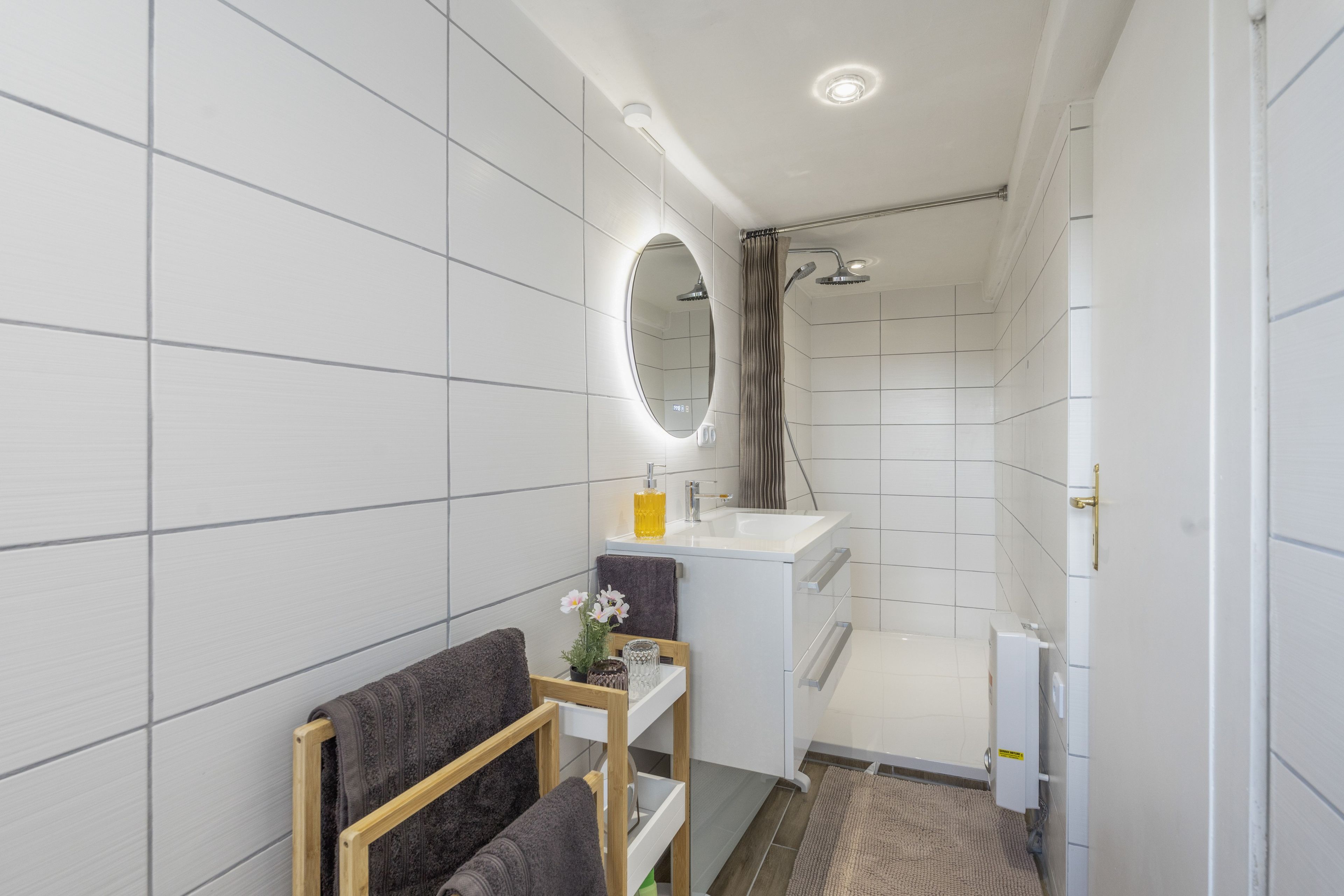 Ein modernes Badezimmer mit Dusche, Waschbecken und Spiegel.