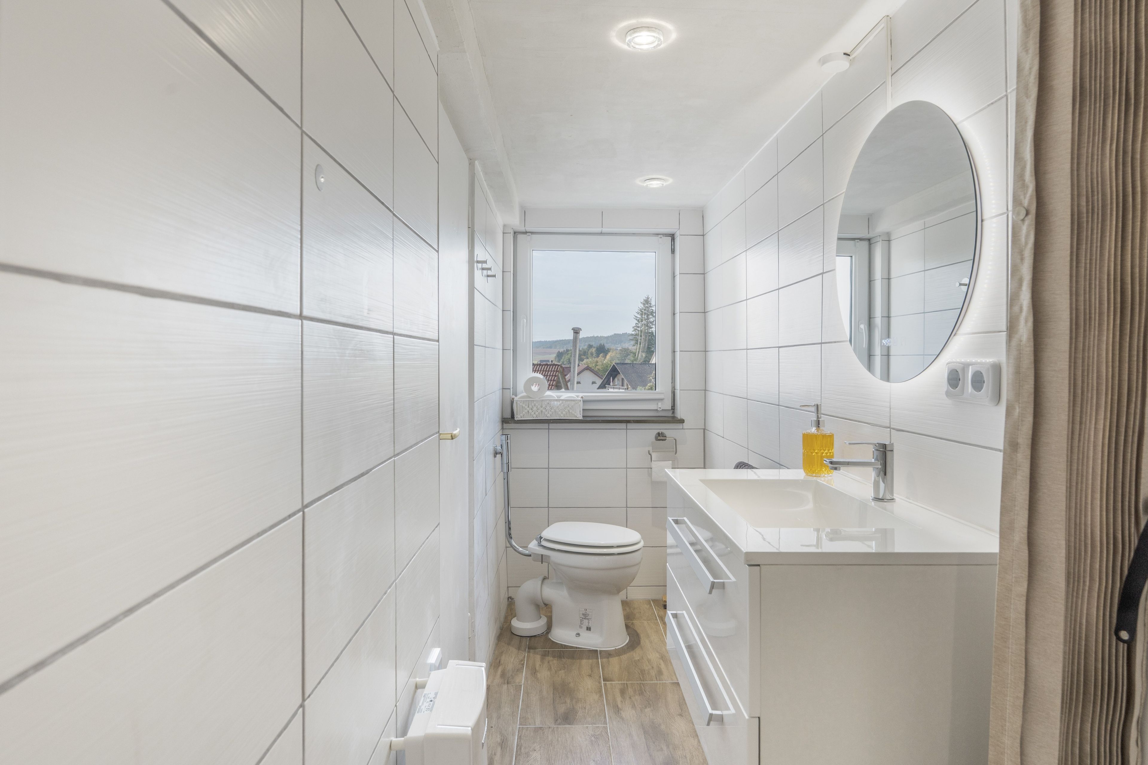 A compact bathroom with a toilet, sink, and mirror.