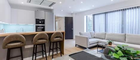 A modern apartment with a kitchen, dining area, and living room.