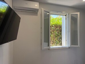 A room with a white wall, a window with white shutters, and an air conditioning unit. - Piano Peri Stay Inn Nature (Cinisi)