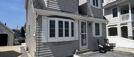 A two-story house with a covered deck and a garage.