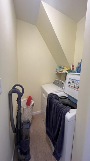 A laundry room with a washing machine, dryer, and stacked laundry. - SPRAY BEACH OCEAN SIDE HOME (Spray Beach)