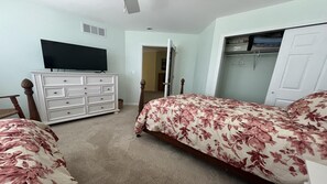 A bedroom with two beds, a dresser, a television, and a closet. - SPRAY BEACH OCEAN SIDE HOME (Spray Beach)