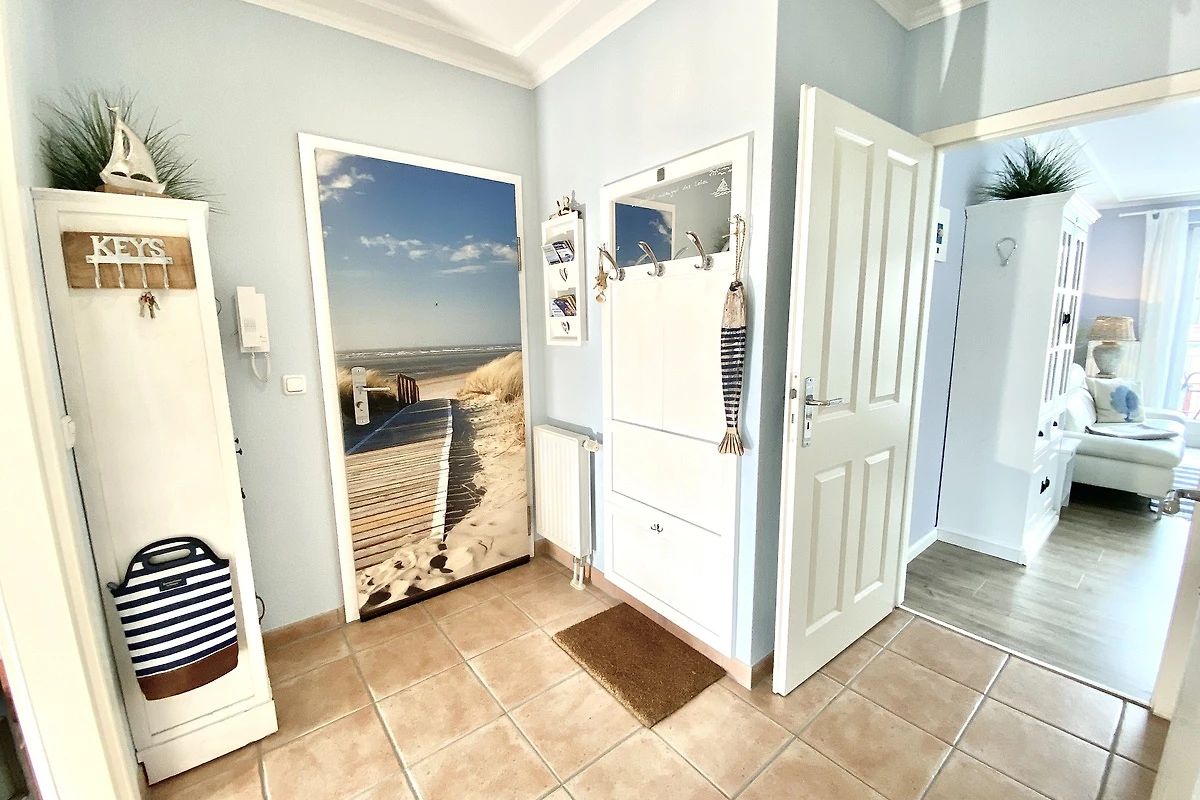 A hallway with a beach mural, a white door, and a white cabinet with a 'KEYS' sign.