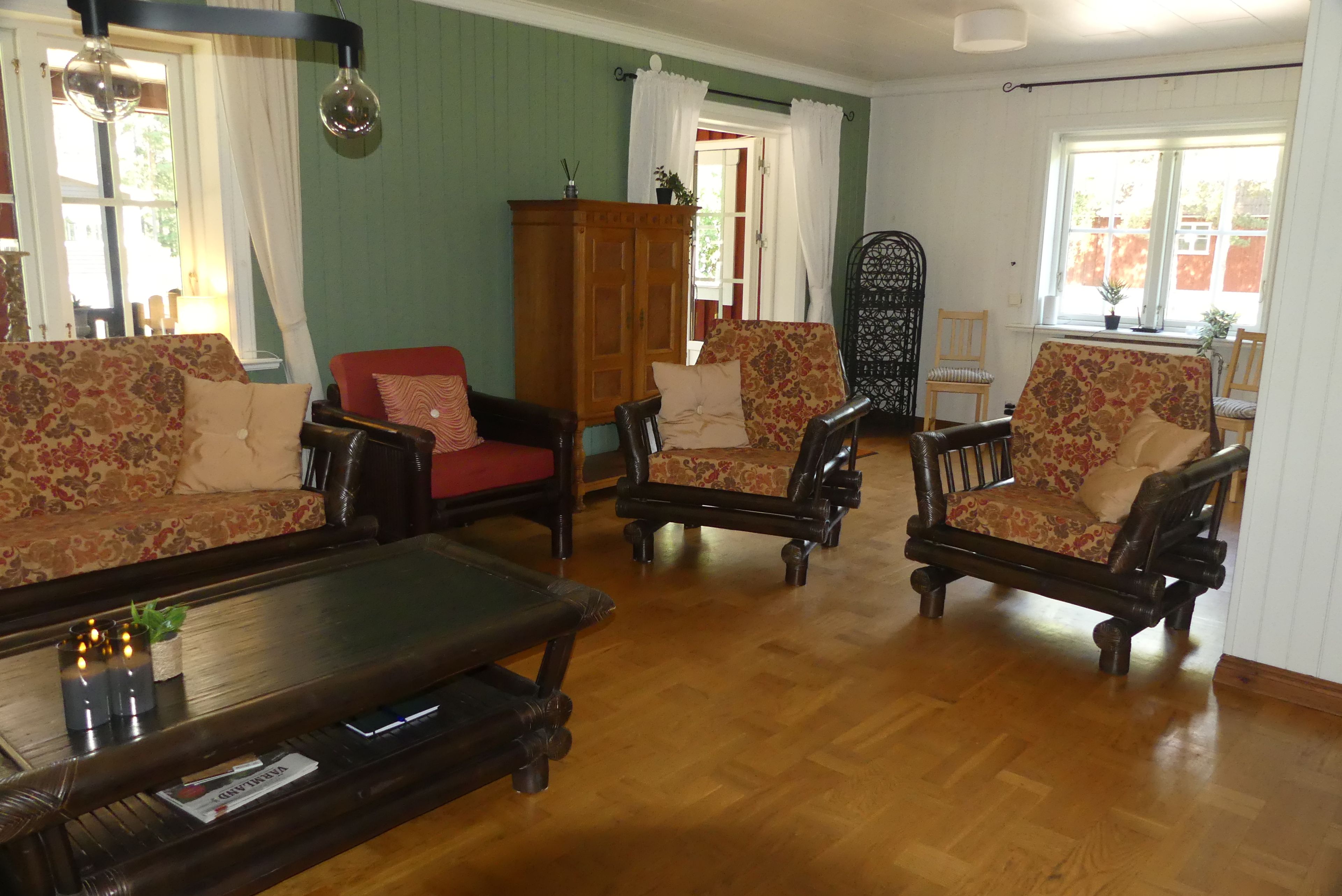 A living room with a wooden floor, two sofas, a coffee table, and a cabinet.