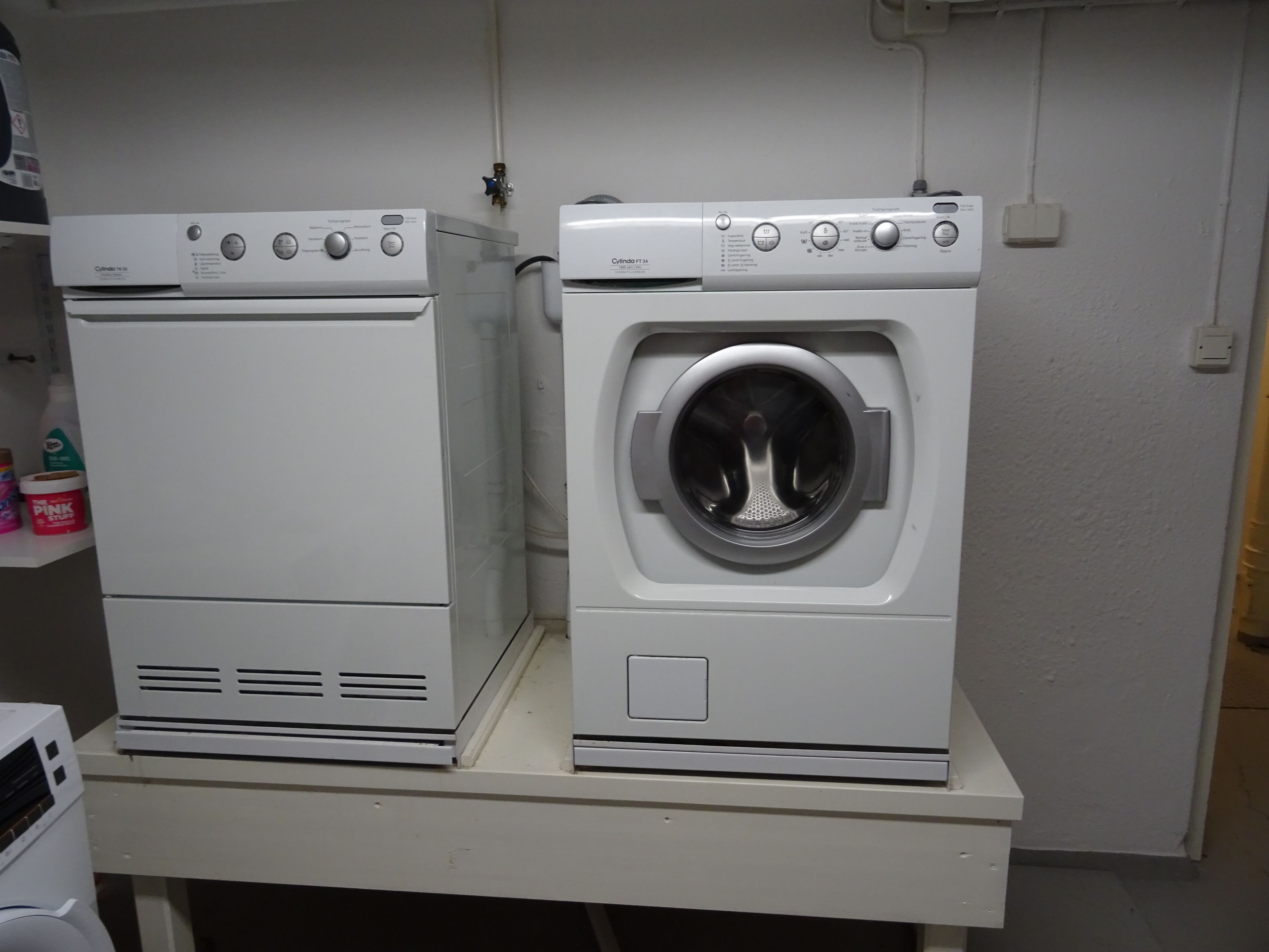 Two white appliances, likely a dryer and a washing machine, on a white countertop.