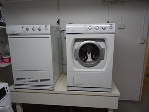 Two white appliances, likely a dryer and a washing machine, on a white countertop.
