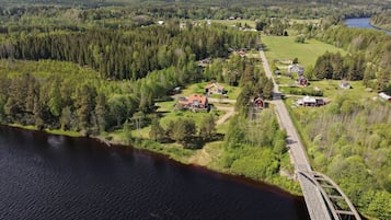 Ett lantligt landskap med en bro, hus och en flod.
