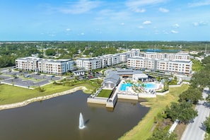 A hotel complex with multiple buildings, a swimming pool, and a fountain. - Landing Beautiful 1BD in Loughman (Davenport)