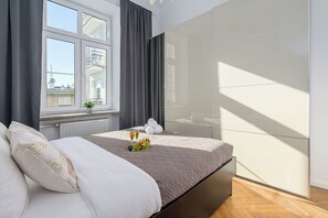 Ein Schlafzimmer mit einem Bett, einem Fenster, einer Heizung und einer Wand mit geometrischem Muster.