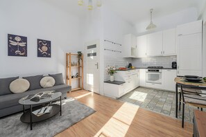 Ein modernes Apartment mit Wohnzimmer, Küchenzeile und Essbereich.