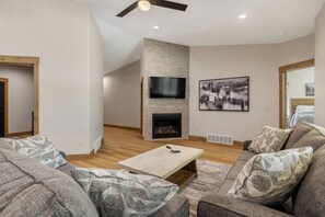 A modern living room with a fireplace, a flat-screen TV, and a large abstract painting. - Single Level Property, All King Suites! Access to Community Clubhouse & Pools (Lead)