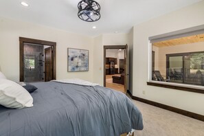 Een slaapkamer met een bed, een raam en uitzicht op de omgeving.