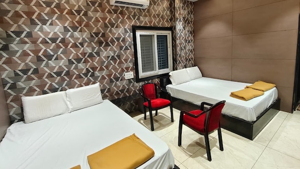 Una habitación de hotel con dos camas, un escritorio y una silla.