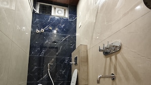 Un baño con inodoro, ducha y lavabo con recipiente decorativo.