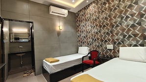 Una habitación de hotel con una cama, una mesita de noche, una silla, un espejo y una pared con diseño.