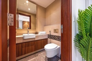 Ein modernes Badezimmer mit einem Holzlagerflansch, einem weißen Waschbecken und einer Toilette.